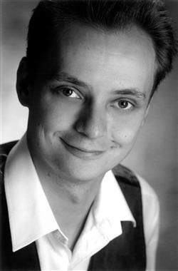 Motiv: Marc Thoms grinsiert in schlichtem Grau